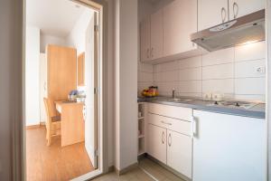una pequeña cocina con armarios blancos y una mesa en Villa Lelas, en Makarska