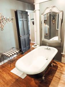 uma casa de banho com uma banheira branca e um espelho. em Park Place em Fort Worth