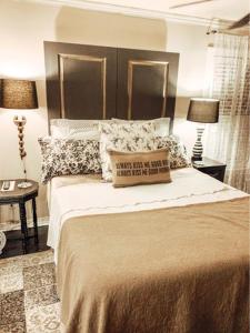una camera da letto con un letto con cuscini e due lampade di Park Place a Fort Worth