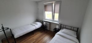 Duas camas num quarto com uma janela em Apartament Północna przy Suntago, Deepspot em Mszczonów