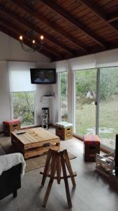 sala de estar con mesa de centro de madera y ventanas en Bramasole Serrano en Villa Serrana