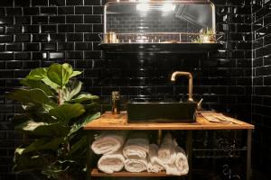 a bathroom with a sink and a black brick wall at “Forte 99” in Venice in Mestre