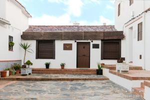 a house with a courtyard in front of it at CASA RURAL LA ZZINETINA in Constantina