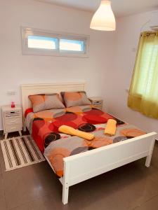 - une chambre avec un lit et une couette colorée dans l'établissement BEST BEAUTIFUL PRIVATE, à Beer-Sheva