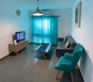 a living room with a couch and a tv at BEST BEAUTIFUL PRIVATE in Beer Sheva