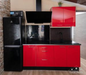 a kitchen with red cabinets and a black refrigerator at Casa Rural La Zzinetina con Jacuzzi in Constantina +21 photos