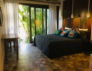 um quarto com uma cama, uma secretária e uma janela em Hacienda La Rusa em Barra de Potosi