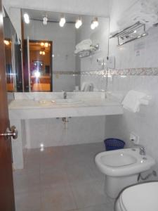 a bathroom with a sink and a toilet and a mirror at Tanger Hotel in Punta del Este