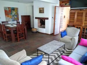 a living room with chairs and a table and a fireplace at RIO y VERDE in Córdoba