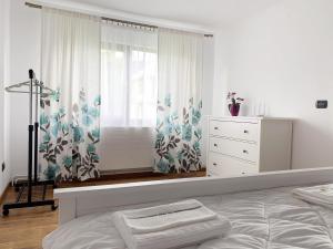 a bedroom with a bed and a window at Casuta Fulgu - sa te simti ca acasa! in Borşa