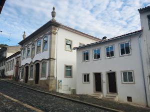 a white building sitting on the side of a street at My Historic House 1 in Bragança