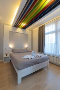 a bedroom with a bed with a rainbow ceiling at Apartments Slana Oaza in Tuzla