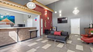 a lobby with a waiting room with a counter and chairs at SureStay Plus Hotel by Best Western Hesperia in Hesperia