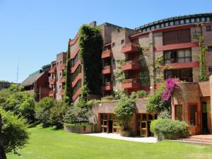 zewnętrzny widok budynku z roślinami w obiekcie Hotel del Bosque w mieście Pinamar