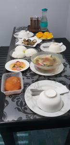czarny stół z talerzami jedzenia w obiekcie Maui's Place w mieście Badian