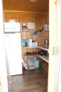 a small kitchen with a refrigerator and a sink at The Woolshed Caravans in Takaka