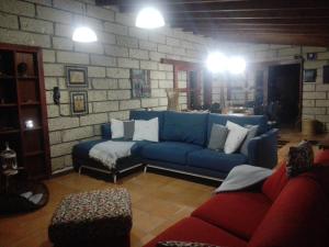 uma sala de estar com um sofá azul e uma parede de tijolos em Casa Zenaida em El Río