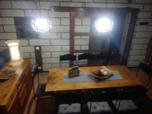 uma mesa de madeira e cadeiras num quarto com duas luzes em Casa Zenaida em El Río