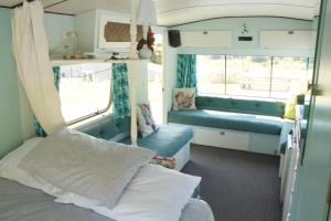 a small room with a bed and a window at The Woolshed Caravans in Takaka