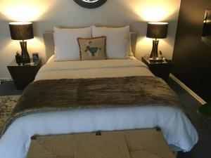 Un dormitorio con una cama grande con dos lámparas. en Olivi, en Yanakie