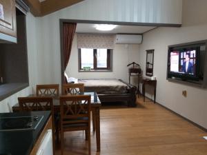 ein Wohnzimmer mit einem Bett, einem Tisch und Stühlen in der Unterkunft Sanaega Pension in Yangyang