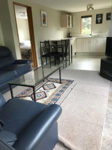 ein Wohnzimmer mit Sofa und Tisch in der Unterkunft Ngapuna Cottage in Christchurch