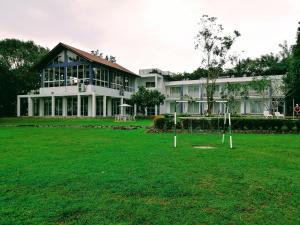 a large white building with a lawn in front of it at Lavendish Wild Safari in Wasgamuwa