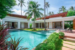 a swimming pool in the backyard of a villa at Pranaluxe 4 Bedroom Pool Villa F1 in Pran Buri