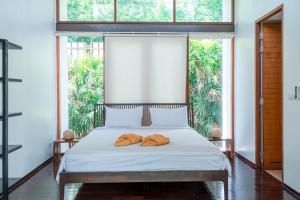 a bedroom with a bed with two pillows on it at Pranaluxe 4 Bedroom Pool Villa F1 in Pran Buri +14 photos