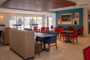 a dining room with tables and red chairs at Holiday Inn Express & Suites Tonawanda - Buffalo Area, an IHG Hotel in Tonawanda