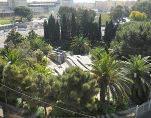 a view of a park with palm trees and a fence at Hotel Traghetto in Civitavecchia