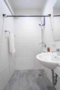 La salle de bains blanche est pourvue d'un lavabo et d'un miroir. dans l'établissement 3Bedrooms White Design in heart of Nimman, à Chiang Mai