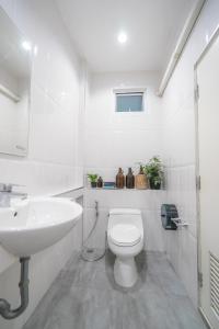 uma casa de banho branca com um WC e um lavatório em 3Bedrooms White Design in heart of Nimman em Chiang Mai