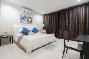 - une chambre avec un lit, un bureau et une chaise dans l'établissement 3Bedrooms White Design in heart of Nimman, à Chiang Mai