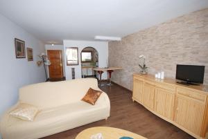 Appartement Cala Conills, Sant Elmo - WIFI gratis في سانت إلم: غرفة معيشة مع أريكة وتلفزيون بشاشة مسطحة
