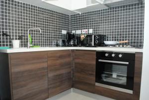 a kitchen with a stove and a sink and a microwave at ASTORIA 1BDR with a gym&pool with views in Nairobi
