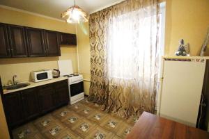 a small kitchen with a sink and a microwave at Апартаменты на пр Победы OrenRoom in Orenburg