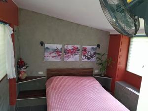 1 dormitorio con 1 cama rosa y 3 cuadros en la pared en Rock Inn Bailan en Ko Chang