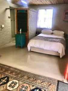 a bedroom with a bed and a chalkboard on the wall at A Piece of Life in Bredasdorp