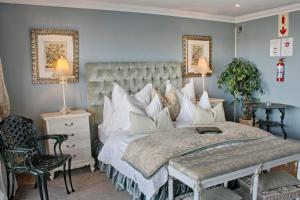 um quarto com uma cama, uma cadeira e 2 candeeiros em Mt Bijoux Preferred Accommodation em Bloubergstrand