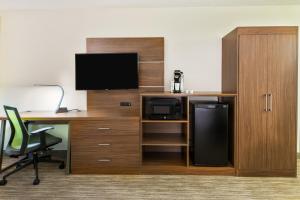 una oficina con escritorio, ordenador y TV en Holiday Inn Express Hotel & Suites Bentonville, an IHG Hotel en Bentonville