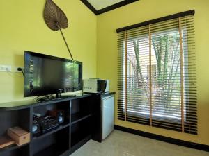 a living room with a flat screen tv and a window at Thai Modern Resort & Spa in Chalong