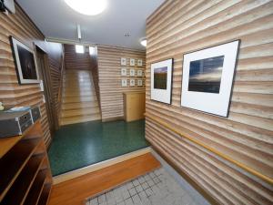 una sauna con paredes de madera y un suelo verde en Pension Ken&Mary, en Biei