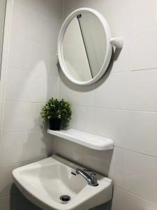 a bathroom with a sink and a mirror on the wall at NK Guesthouse 2 in Bangkok