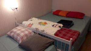 a baby crib in a room with a bed with a crib at Nipu -Beside City Center, Bus and Train Station in Oulu