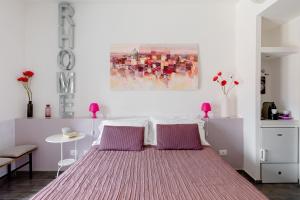 una camera da letto con un grande letto con cuscini viola di Rhome Accomodation a Roma