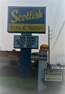 a sign for a restaurant with several signs at Scottish Inn & Suites IAH West in Westfield