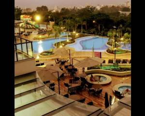 - une vue sur une grande piscine avec des tables et des parasols dans l'établissement Alta vista termas resort, à Caldas Novas