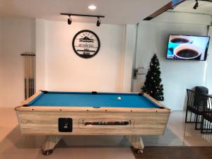 a pool table in a living room with a christmas tree at Richmond Nan Hotel in Nan