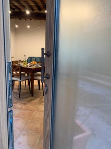 una porta che conduce a una sala da pranzo con tavolo di Casa vacanza vicolo degli orti a Monticiano